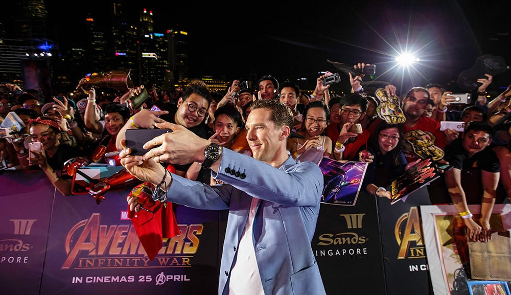 Cumberbatch poses with fans on the purple carpet